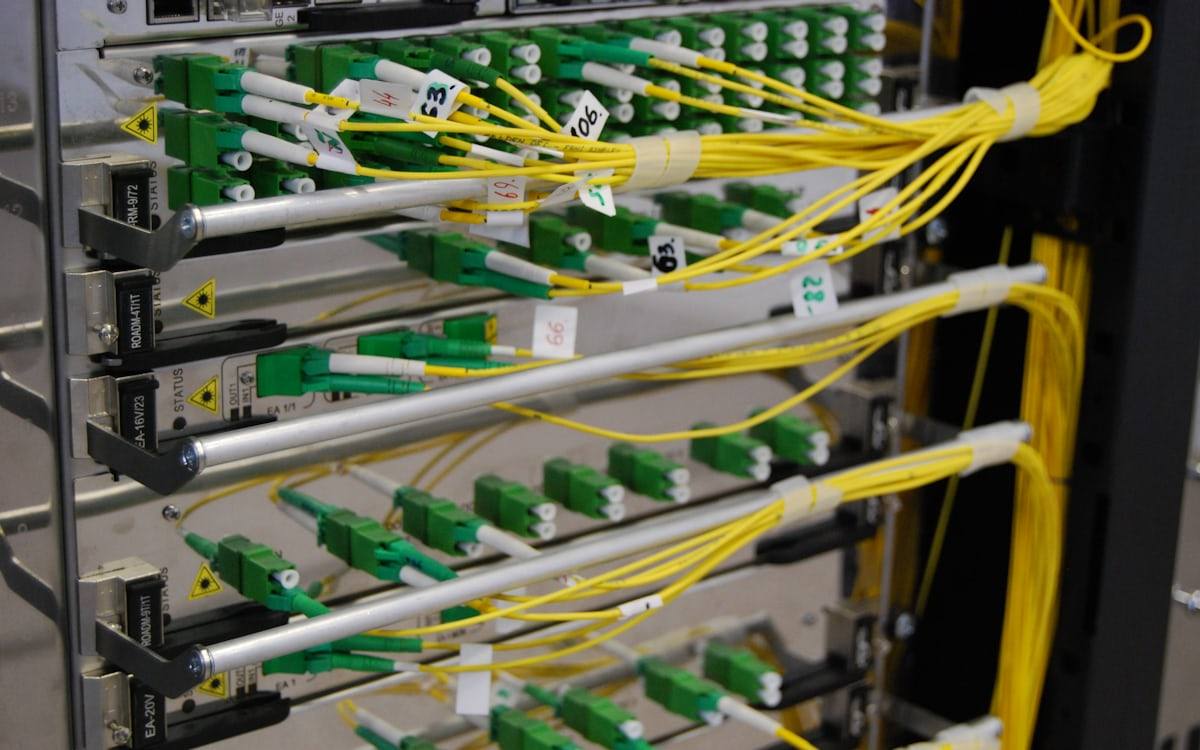Distribuidor óptico com conectores APC verdes e cordões monomodo amarelos identificados